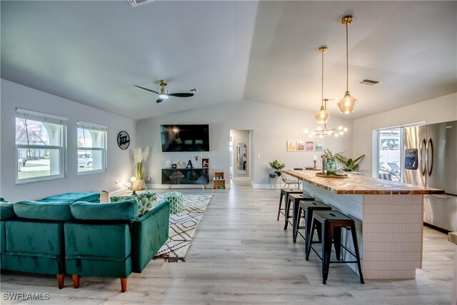 917 SW 23rd St, Cape Coral, FL 33991 - living room featuring lofted ceiling, light wood-style flooring, a ceiling fan, and a chandelier