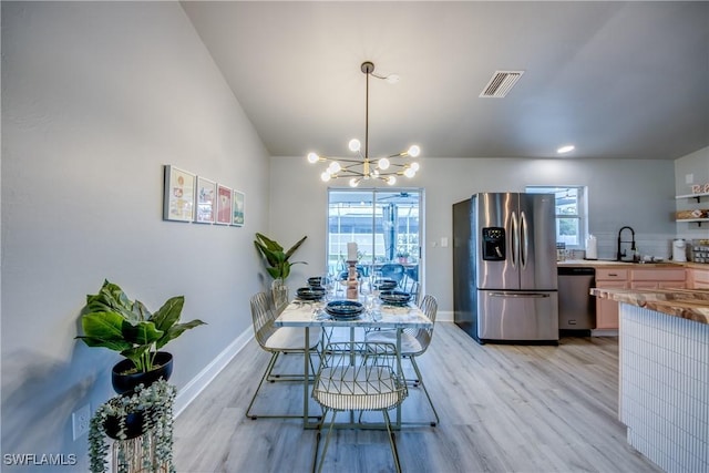 917 SW 23rd St, Cape Coral, FL 33991 - dining space with healthy amount of natural light, light wood-style floors, and a chandelier