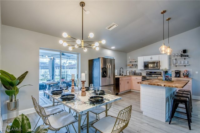 917 SW 23rd St, Cape Coral, FL 33991 - dining space with vaulted ceiling, light wood-type flooring, and a chandelier