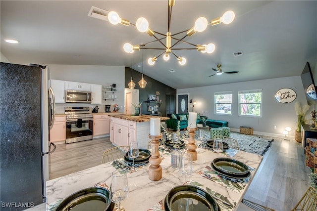 917 SW 23rd St, Cape Coral, FL 33991 - dining area with vaulted ceiling, light wood-style floors, ceiling fan, and a chandelier