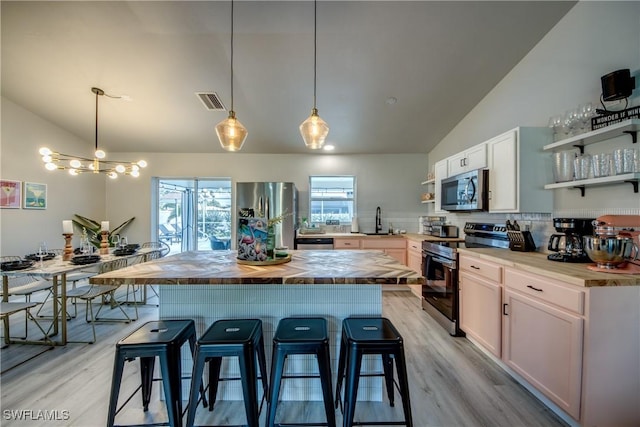 917 SW 23rd St, Cape Coral, FL 33991 - kitchen featuring stainless steel appliances, open shelves, vaulted ceiling, wooden counters, and a kitchen breakfast bar