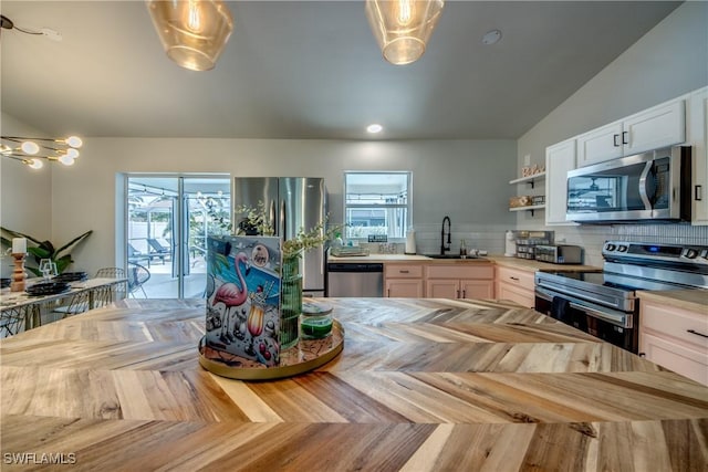 917 SW 23rd St, Cape Coral, FL 33991 - kitchen with appliances with stainless steel finishes, butcher block countertops, open shelves, and decorative backsplash