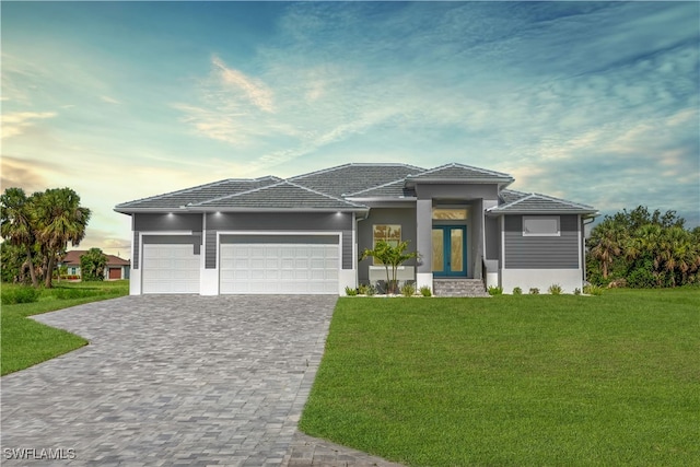 193 Rotonda Blvd S, Rotonda West, FL 33947 - prairie-style house with an attached garage, a front lawn, decorative driveway, a tile roof, and stucco siding