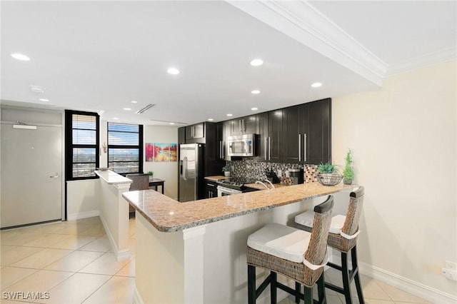 380 Seaview Ct Unit 1505, Marco Island, FL 34145 - kitchen with stainless steel appliances, light tile patterned flooring, ornamental molding, light stone counters, and tasteful backsplash