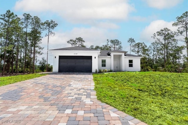 1518 Williams Ave, Lehigh Acres, FL 33972 - view of front of home featuring decorative driveway, stucco siding, an attached garage, and a front lawn