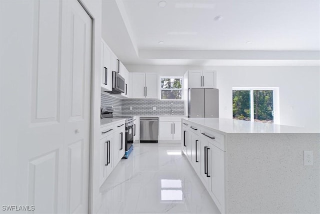 1518 Williams Ave, Lehigh Acres, FL 33972 - kitchen with stainless steel appliances, tasteful backsplash, light marble finish floors, white cabinets, and recessed lighting