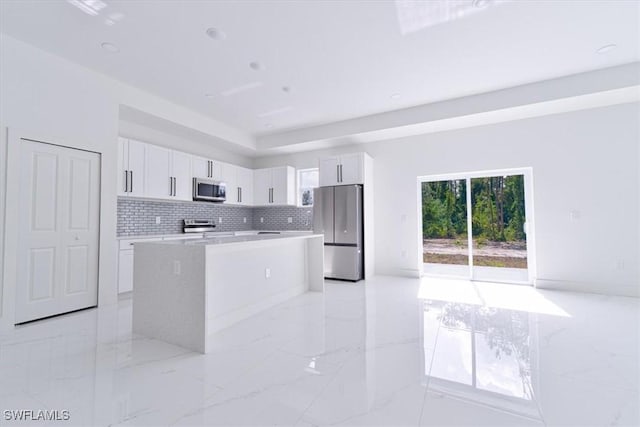 1518 Williams Ave, Lehigh Acres, FL 33972 - kitchen featuring stainless steel appliances, light marble finish floors, a kitchen island, light countertops, and white cabinets