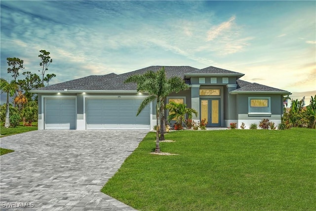 291 Rotonda Blvd S, Rotonda West, FL 33947 - prairie-style house featuring decorative driveway, stucco siding, a garage, a front yard, and roof with shingles
