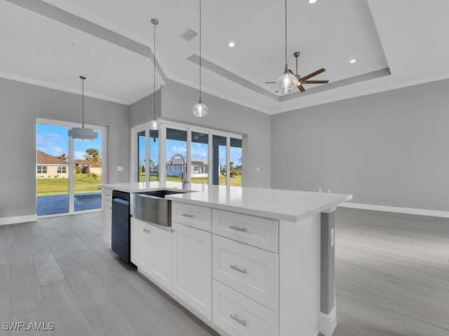 291 Rotonda Blvd S, Rotonda West, FL 33947 - kitchen with a ceiling fan, light countertops, a tray ceiling, an island with sink, and plenty of natural light