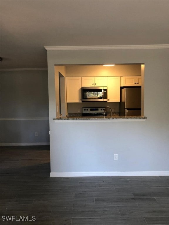 2929 Winkler Ave Unit 1008, Fort Myers, FL 33916 - kitchen featuring stainless steel appliances, ornamental molding, white cabinetry, dark wood-type flooring, and dark stone counters