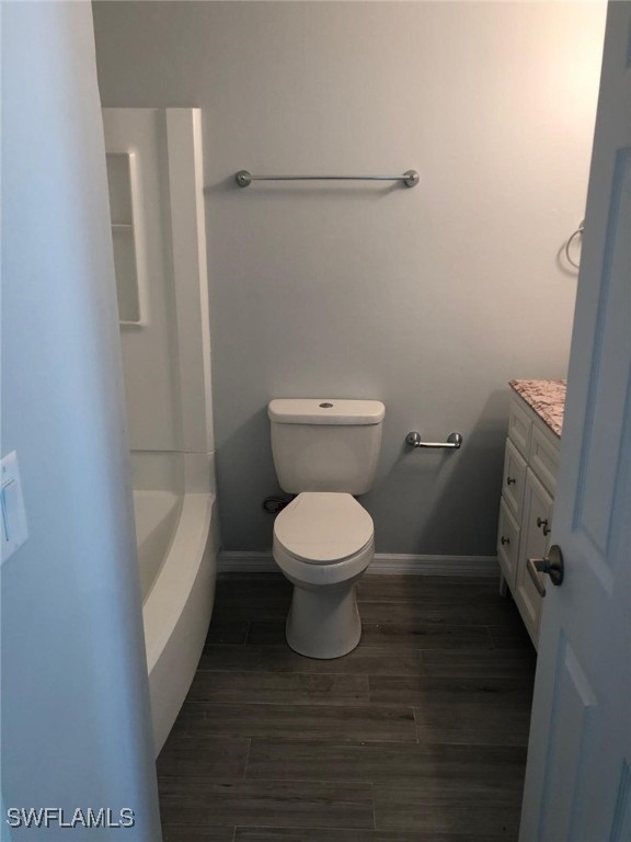 2929 Winkler Ave Unit 1008, Fort Myers, FL 33916 - full bath with vanity, a tub to relax in, and wood finished floors
