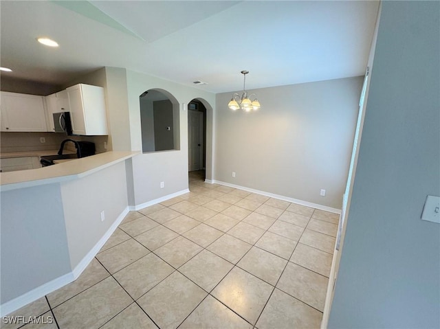 4916 7th St W, Lehigh Acres, FL 33971 - kitchen featuring range, stainless steel microwave, a chandelier, light countertops, and white cabinetry