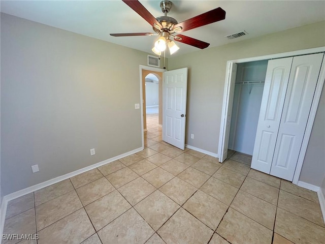 4916 7th St W, Lehigh Acres, FL 33971 - unfurnished bedroom with light tile patterned flooring, a closet, ceiling fan, and arched walkways