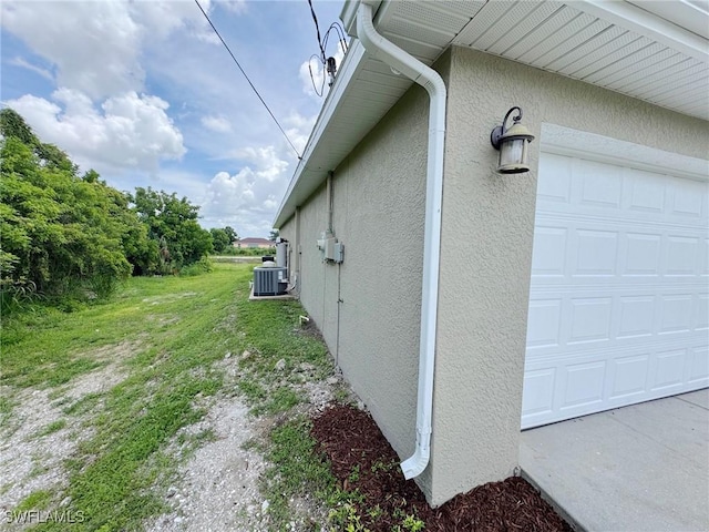 4916 7th St W, Lehigh Acres, FL 33971 - view of side of home with stucco siding and a garage