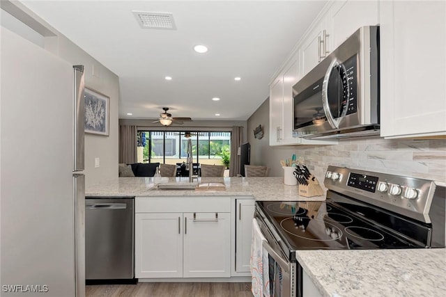 1752 Stickney Point Rd Unit 102, Sarasota, FL 34231 - kitchen with appliances with stainless steel finishes, white cabinetry, backsplash, ceiling fan, and recessed lighting