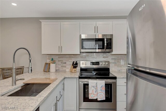 1752 Stickney Point Rd Unit 102, Sarasota, FL 34231 - kitchen featuring stainless steel appliances, white cabinetry, tasteful backsplash, and recessed lighting