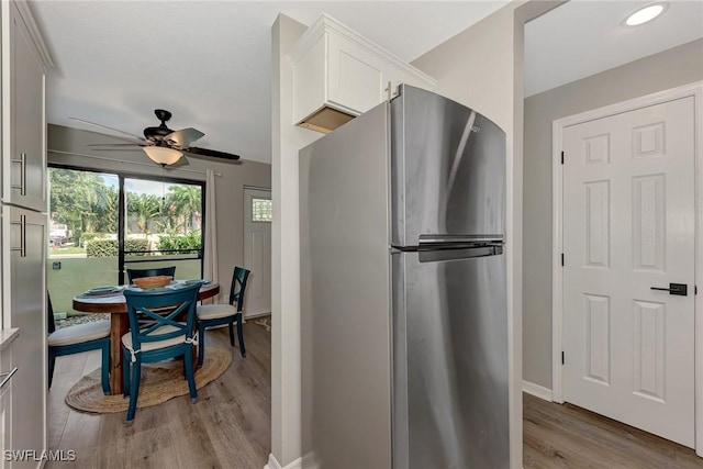 1752 Stickney Point Rd Unit 102, Sarasota, FL 34231 - kitchen featuring freestanding refrigerator, light wood-style flooring, white cabinetry, ceiling fan, and light countertops