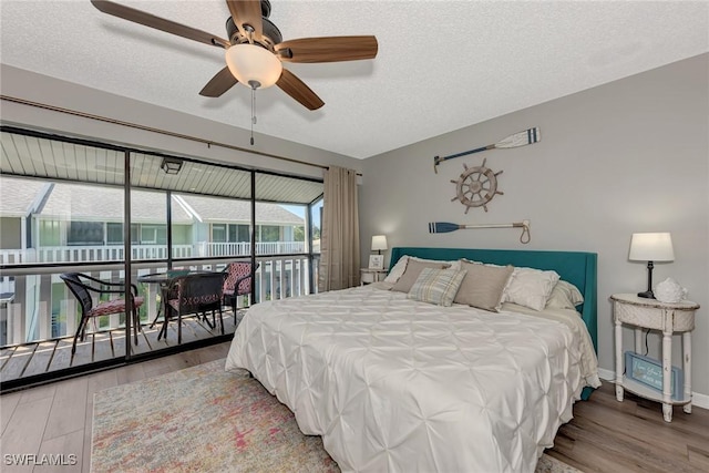 1752 Stickney Point Rd Unit 102, Sarasota, FL 34231 - bedroom with wood finished floors, access to exterior, a textured ceiling, and ceiling fan