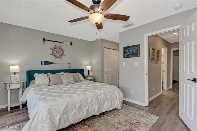 1752 Stickney Point Rd Unit 102, Sarasota, FL 34231 - bedroom featuring light wood-style floors, a closet, a ceiling fan, and a textured ceiling