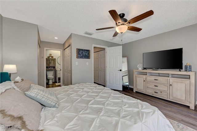 1752 Stickney Point Rd Unit 102, Sarasota, FL 34231 - bedroom with dark wood-type flooring, ensuite bath, recessed lighting, a ceiling fan, and a textured ceiling