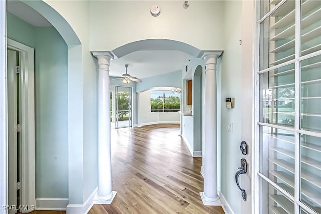 3082 Windsong Ct Unit 303, Naples, FL 34109 - entrance foyer featuring arched walkways, ornate columns, wood finished floors, and a ceiling fan