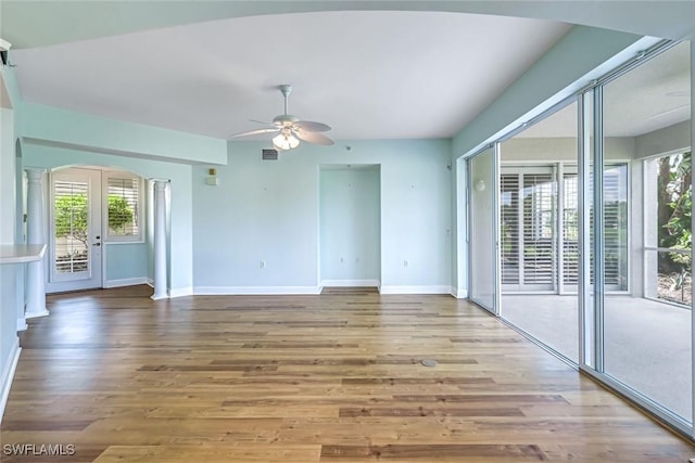 3082 Windsong Ct Unit 303, Naples, FL 34109 - unfurnished room featuring ceiling fan, arched walkways, and wood finished floors