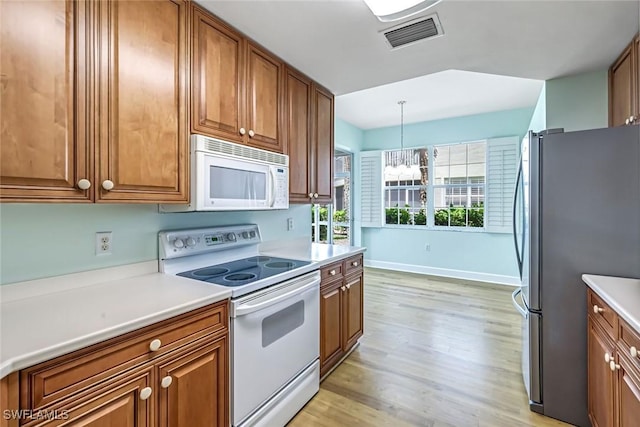 3082 Windsong Ct Unit 303, Naples, FL 34109 - kitchen with white appliances, brown cabinets, light wood-type flooring, a chandelier, and light countertops
