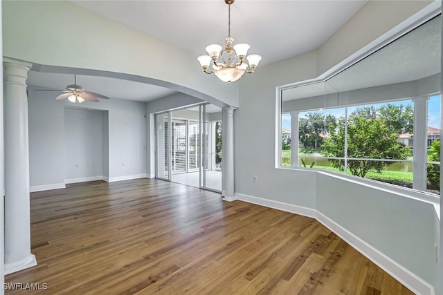3082 Windsong Ct Unit 303, Naples, FL 34109 - unfurnished room featuring ornate columns, arched walkways, plenty of natural light, and wood finished floors