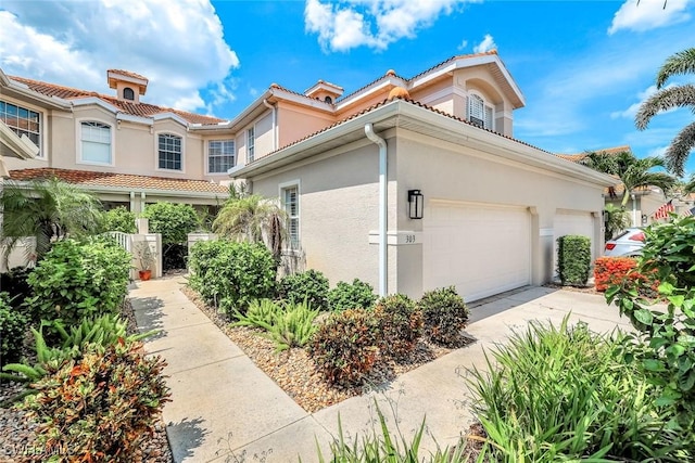 3082 Windsong Ct Unit 303, Naples, FL 34109 - view of home's exterior with stucco siding, driveway, and a tile roof