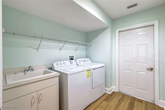 3082 Windsong Ct Unit 303, Naples, FL 34109 - laundry room featuring washer and dryer, light wood-style flooring, and cabinet space
