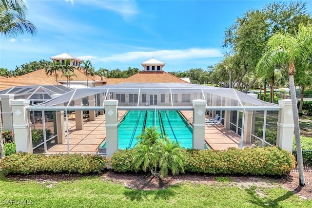3082 Windsong Ct Unit 303, Naples, FL 34109 - back of house featuring a patio, a community pool, and glass enclosure