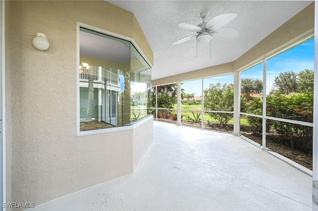 3082 Windsong Ct Unit 303, Naples, FL 34109 - unfurnished sunroom featuring a textured wall, a ceiling fan, concrete floors, and a textured ceiling