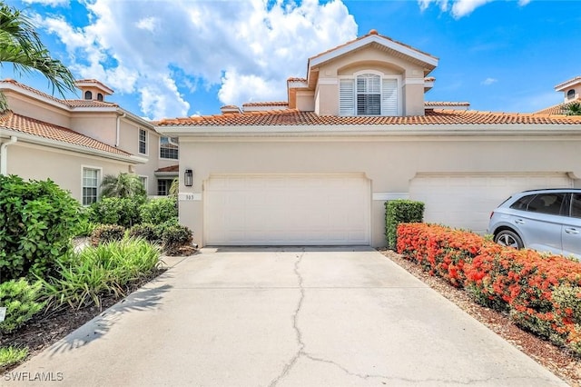 3082 Windsong Ct Unit 303, Naples, FL 34109 - mediterranean / spanish-style home with stucco siding, a tiled roof, driveway, and a garage