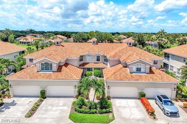 3082 Windsong Ct Unit 303, Naples, FL 34109 - view of front facade with a tiled roof, stucco siding, concrete driveway, and a residential view