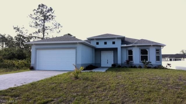 2715 34th St W, Lehigh Acres, FL 33971 - prairie-style house with an attached garage, driveway, stucco siding, and a front yard