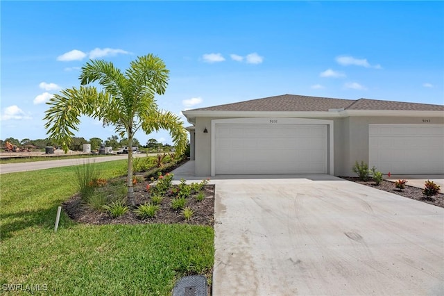9051 Leatherwood Loop, Lehigh Acres, FL 33936 - view of front of house featuring stucco siding, an attached garage, concrete driveway, and a front lawn