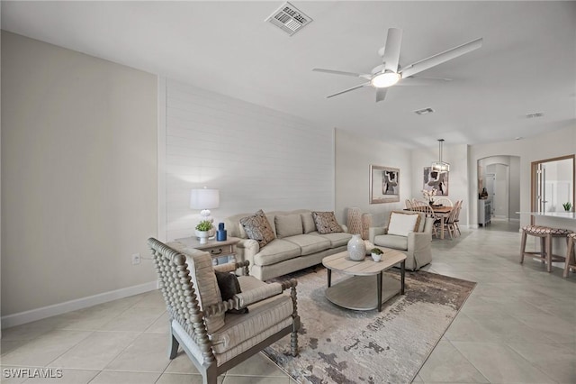 9051 Leatherwood Loop, Lehigh Acres, FL 33936 - living area with arched walkways, light tile patterned floors, and a ceiling fan
