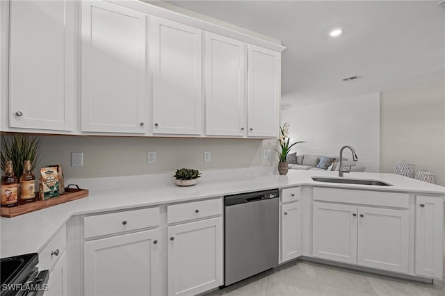 9051 Leatherwood Loop, Lehigh Acres, FL 33936 - kitchen with stainless steel dishwasher, a peninsula, range with electric cooktop, light countertops, and white cabinetry