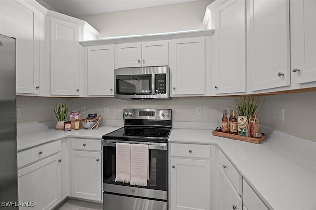 9051 Leatherwood Loop, Lehigh Acres, FL 33936 - kitchen featuring stainless steel appliances, light countertops, and white cabinets