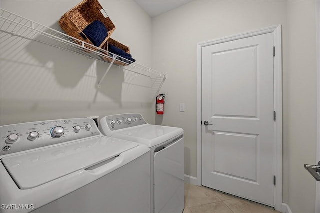 9051 Leatherwood Loop, Lehigh Acres, FL 33936 - laundry room with washing machine and clothes dryer and light tile patterned flooring