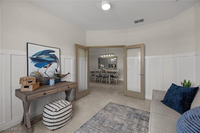 9051 Leatherwood Loop, Lehigh Acres, FL 33936 - living room with a decorative wall, light tile patterned floors, and wainscoting