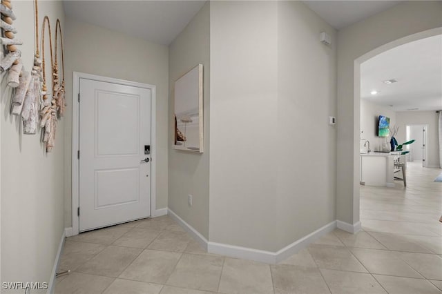 9051 Leatherwood Loop, Lehigh Acres, FL 33936 - corridor featuring arched walkways, light tile patterned flooring, and recessed lighting