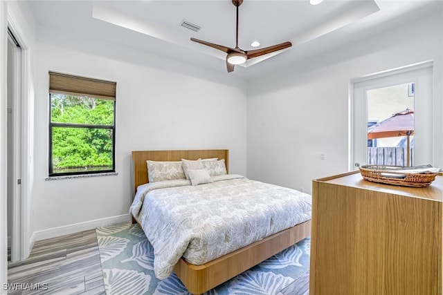 3980 Full Moon Ct, Naples, FL 34112 - bedroom featuring a tray ceiling, light wood finished floors, recessed lighting, and ceiling fan