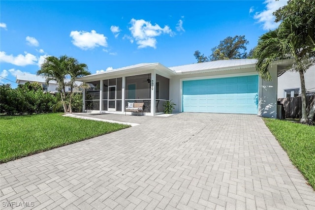 3980 Full Moon Ct, Naples, FL 34112 - single story home with a sunroom, decorative driveway, a garage, a front yard, and a ceiling fan