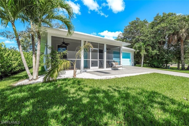 3980 Full Moon Ct, Naples, FL 34112 - back of property with ceiling fan, driveway, a lawn, an attached garage, and a sunroom