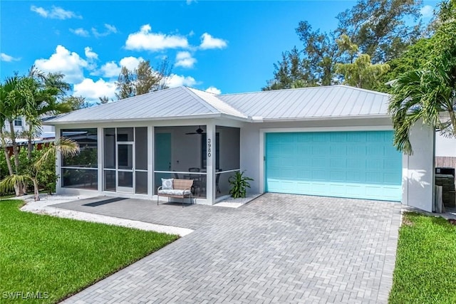 3980 Full Moon Ct, Naples, FL 34112 - ranch-style home with a garage, decorative driveway, a front lawn, and a metal roof