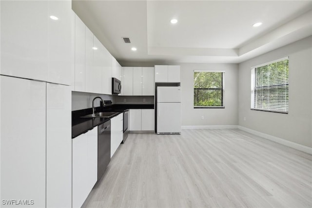 1836 Jacinto Ave, Lehigh Acres, FL 33972 - kitchen with appliances with stainless steel finishes, modern cabinets, dark countertops, a raised ceiling, and white cabinetry