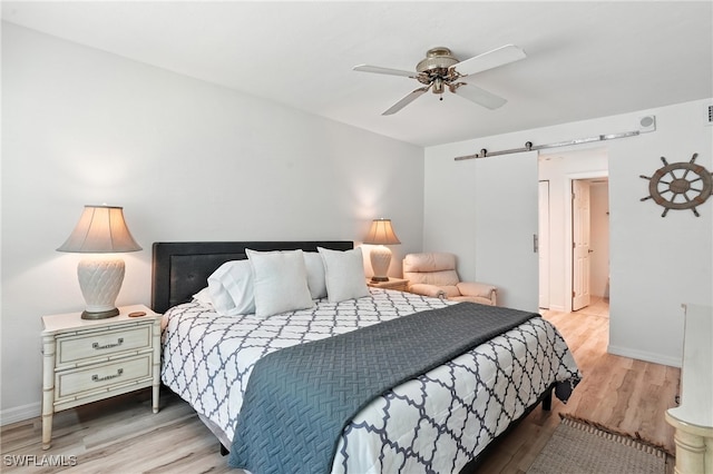 4265 Bay Beach Ln Unit 226, Fort Myers Beach, FL 33931 - bedroom featuring a barn door, wood finished floors, and ceiling fan