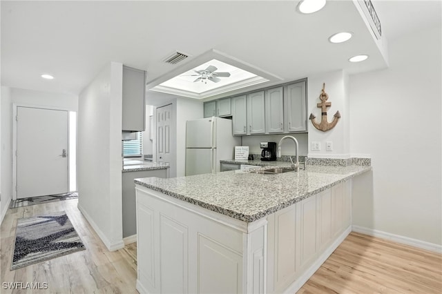 4265 Bay Beach Ln Unit 226, Fort Myers Beach, FL 33931 - kitchen with freestanding refrigerator, a peninsula, light wood-type flooring, recessed lighting, and light stone counters