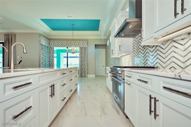 3309 SW 2nd Ln, Cape Coral, FL 33991 - kitchen with premium range hood, high end stainless steel range oven, crown molding, light marble finish floors, and a raised ceiling